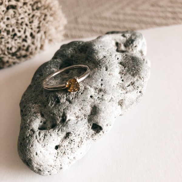 Ring on a textured stone surface with a neutral background